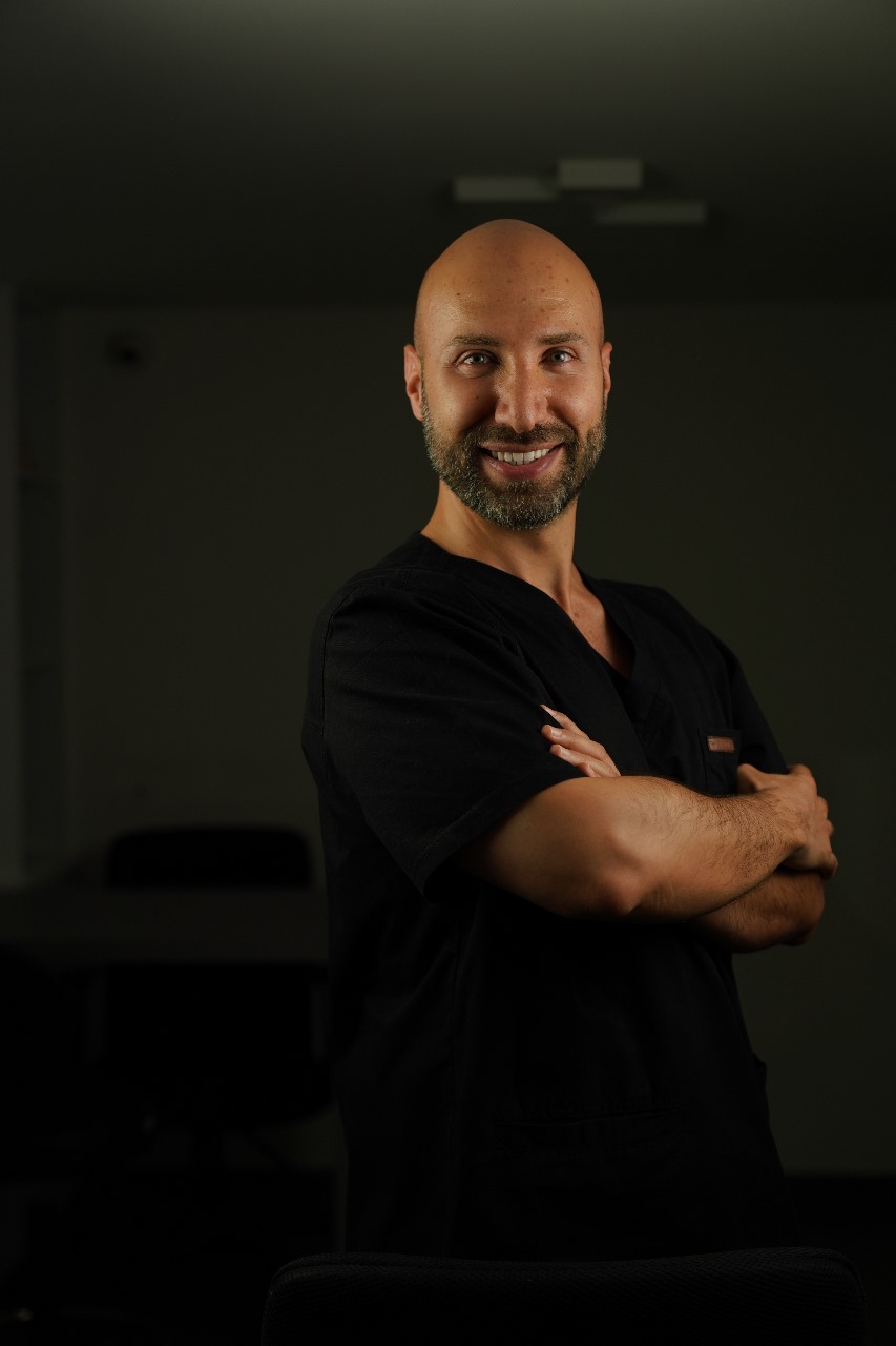 Portrait of a clinician in black scrubs, arms crossed